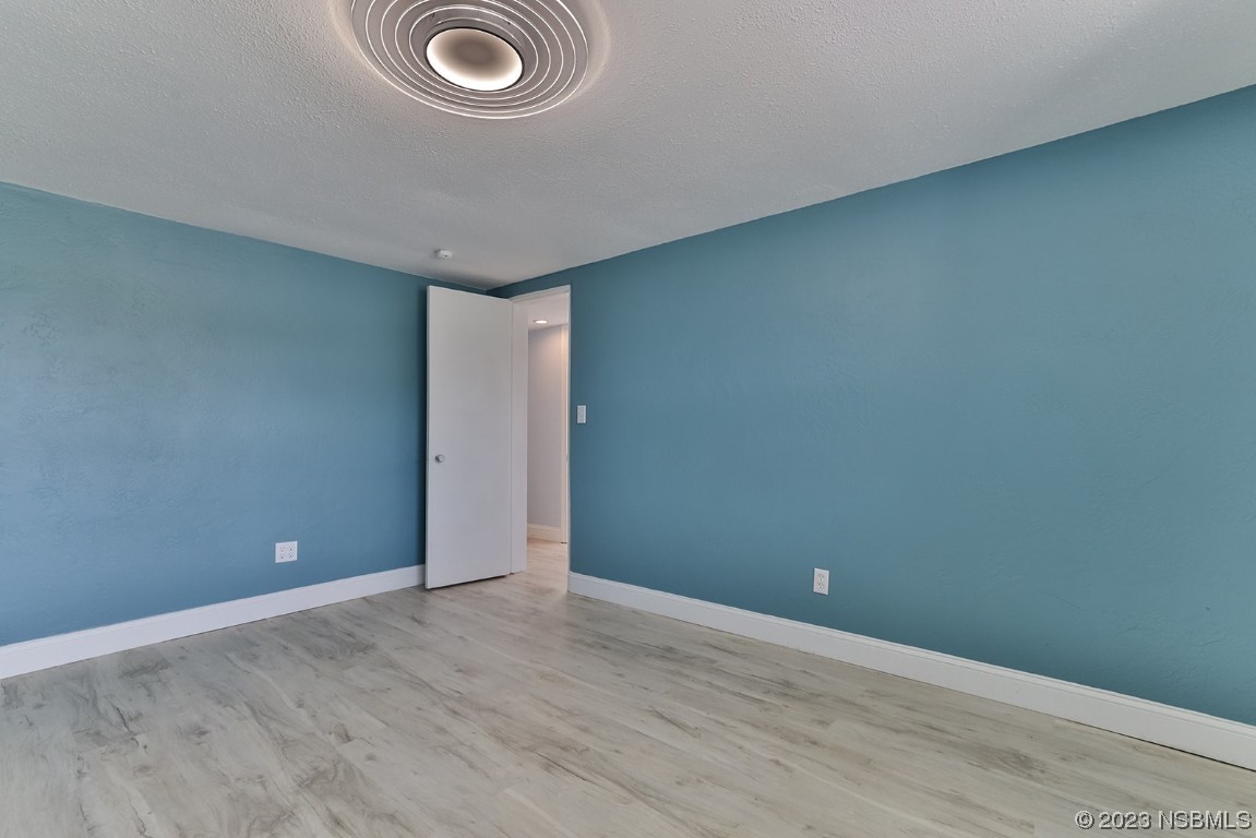 133 Milton Road Daytona Beach, FL 32118 - Photo 48 of 70 an empty room with wooden floor and sliding door