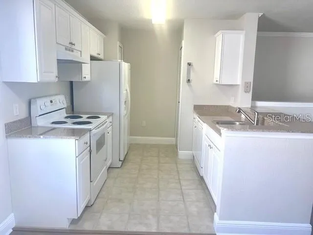 a view of kitchen with stainless steel appliances wooden floor and window