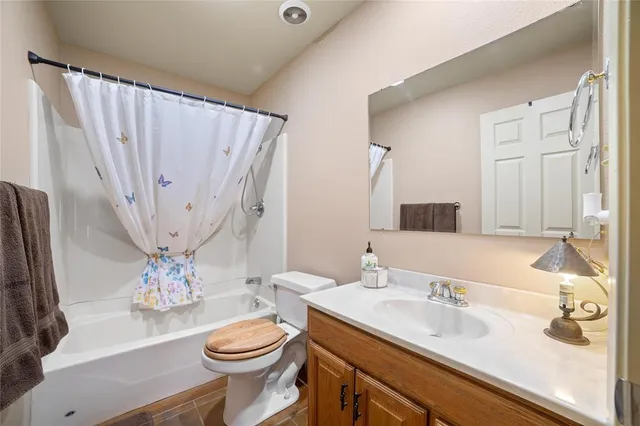 a bathroom with a granite countertop sink toilet and a mirror