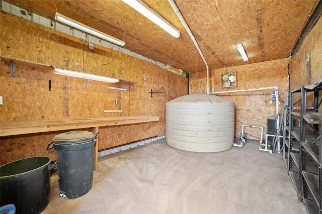a room with water heater and wooden cabinets