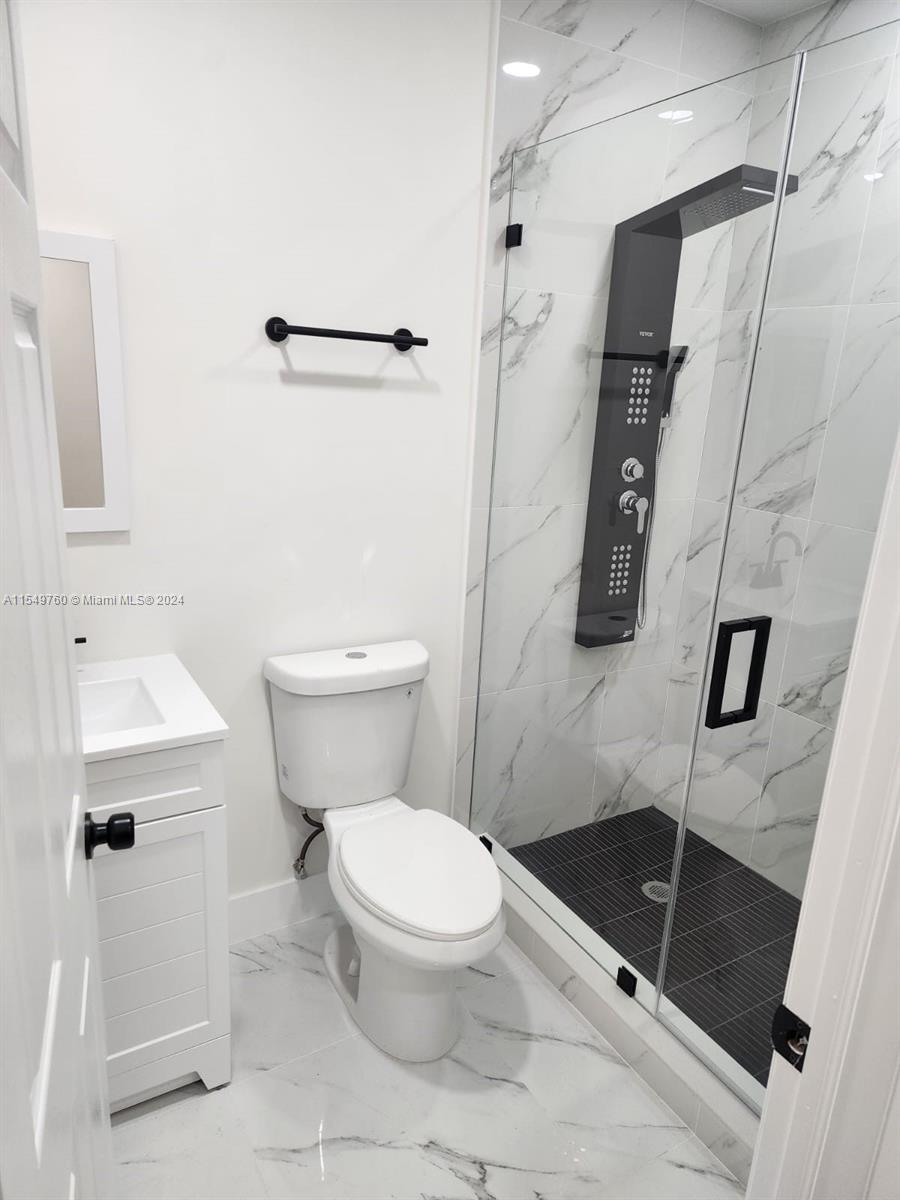 a bathroom with a toilet a sink and shower