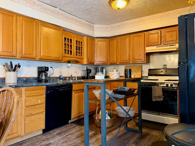 a kitchen with stainless steel appliances granite countertop sink stove top oven and cabinets