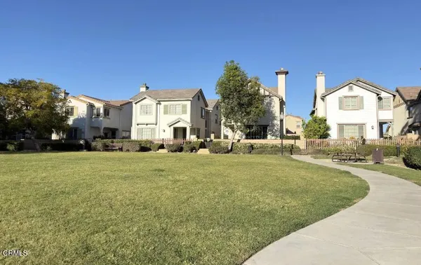 a view of a big house with a big yard and large trees