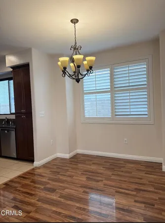 a view of a room with wooden floor and chandelier