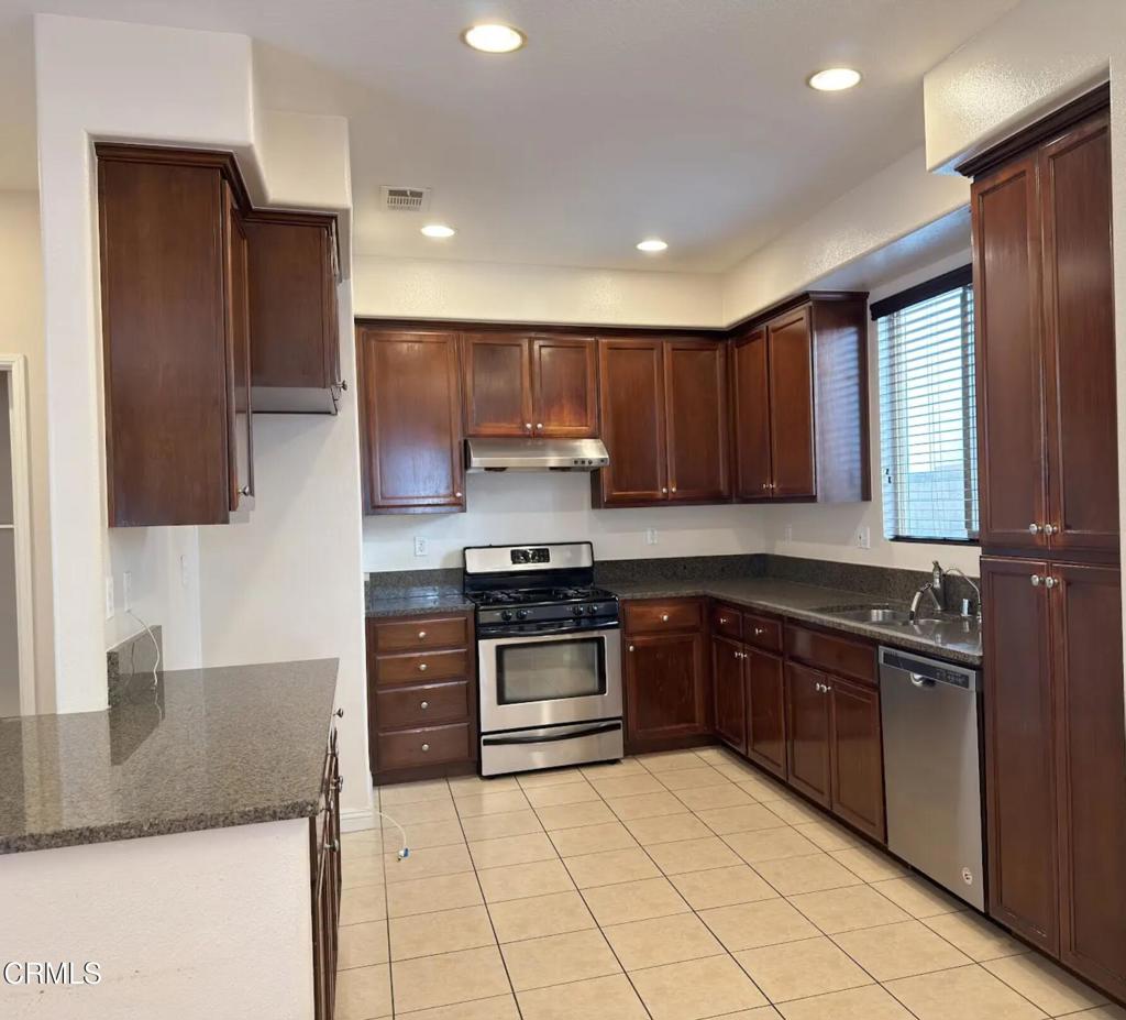 433 Merced Court Corona, CA 92878 - Photo 6 of 22 a kitchen with stainless steel appliances granite countertop a stove a sink and a microwave