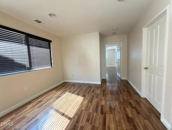 a view of a room with wooden floor and a window