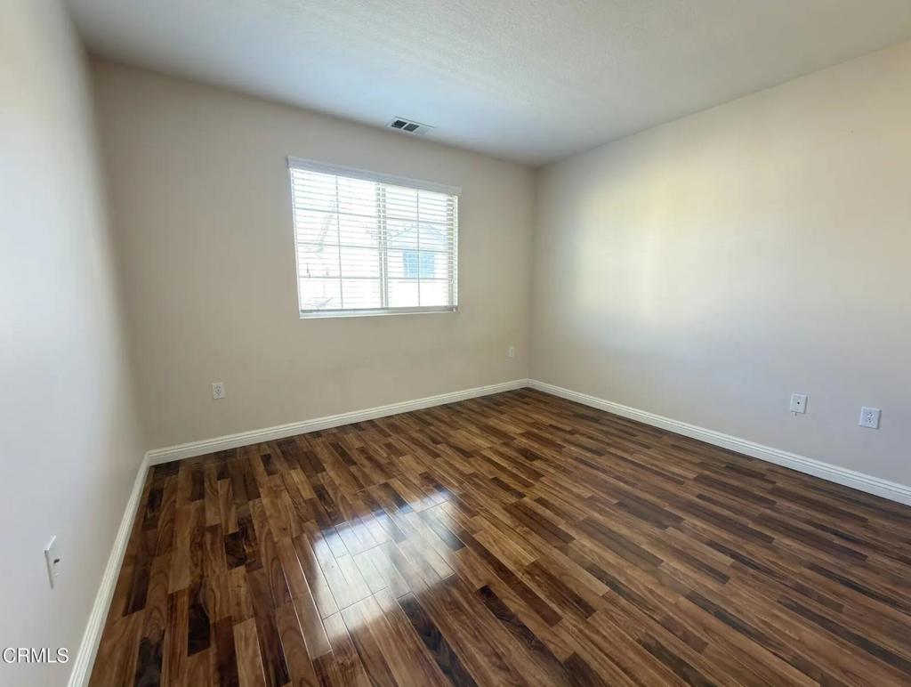 433 Merced Court Corona, CA 92878 - Photo 10 of 22 wooden floor in an empty room with a window