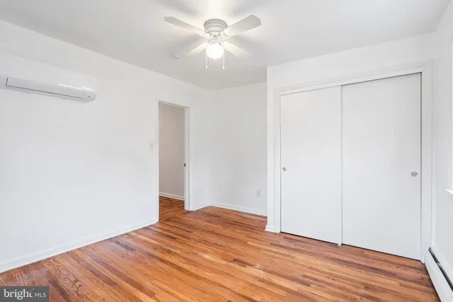 a view of a room with wooden floor and a ceiling fan