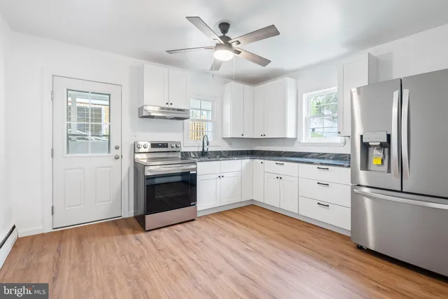 a kitchen with a stove a refrigerator and a sink