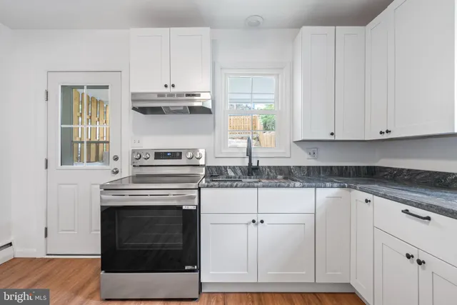a kitchen with white cabinets and appliances