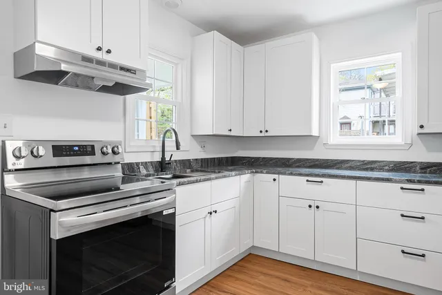 a kitchen with cabinets appliances a sink and a window