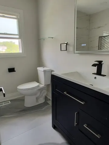 a bathroom with a sink a toilet and a window