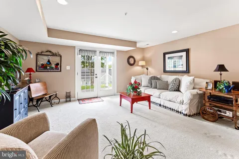 a living room with furniture and a refrigerator