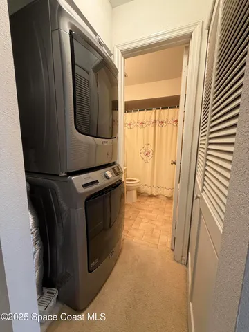 a utility room with wooden floor washer and dryer