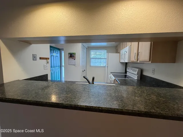 a kitchen with kitchen island a sink a stove and a window