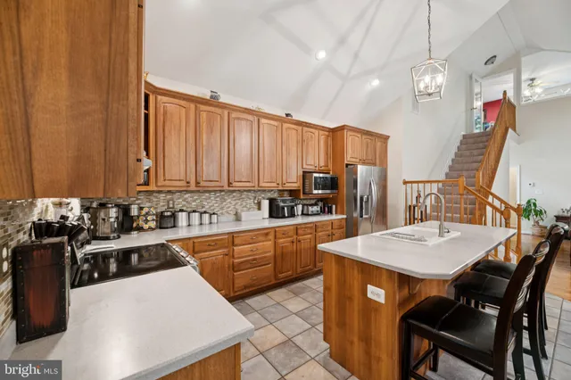 a kitchen with stainless steel appliances granite countertop a stove a refrigerator a sink dishwasher with a dining table and chairs