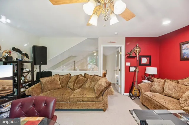 a living room with furniture a chandelier and a flat screen tv
