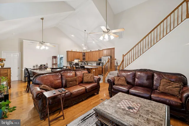 a living room with furniture a ceiling fan and a rug