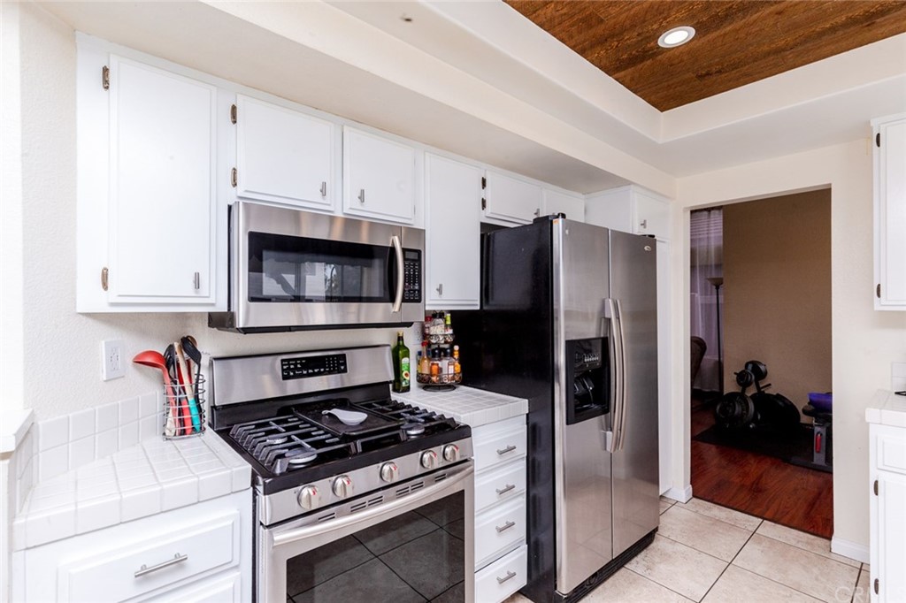13058 Red Corral Drive Corona, CA 92883 - Photo 12 of 37 a kitchen with stainless steel appliances a stove a microwave and a refrigerator