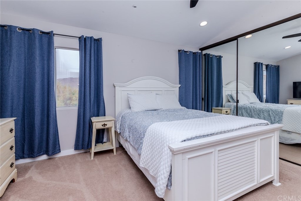 13058 Red Corral Drive Corona, CA 92883 - Photo 17 of 37 a bedroom with a bed and a large mirror