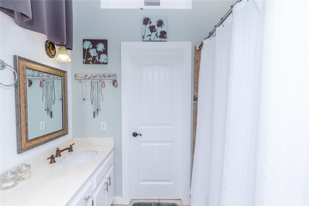 13058 Red Corral Drive Corona, CA 92883 - Photo 20 of 37 a bathroom with a sink a mirror and a shower