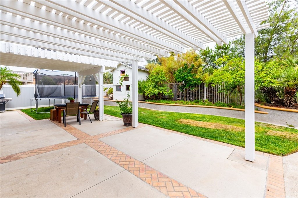 13058 Red Corral Drive Corona, CA 92883 - Photo 28 of 37 a view of a patio with table and chairs under an umbrella
