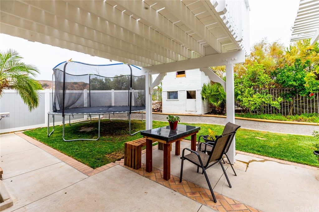 13058 Red Corral Drive Corona, CA 92883 - Photo 31 of 37 a view of outdoor dining space with a patio and a garden