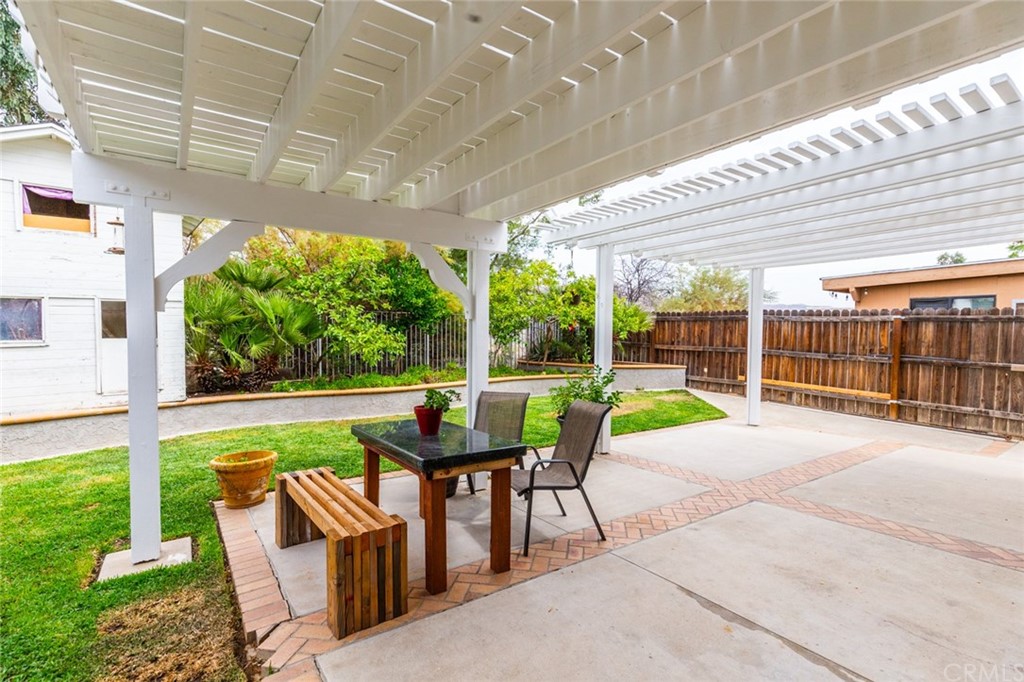 13058 Red Corral Drive Corona, CA 92883 - Photo 33 of 37 a view of a patio with table and chairs potted plants with floor to ceiling window