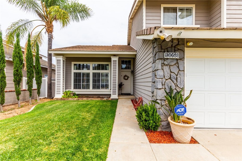 13058 Red Corral Drive Corona, CA 92883 - Photo 6 of 37 a front view of a house with a garden and plants