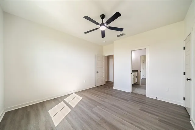 a view of room with wooden floor and ceiling fan