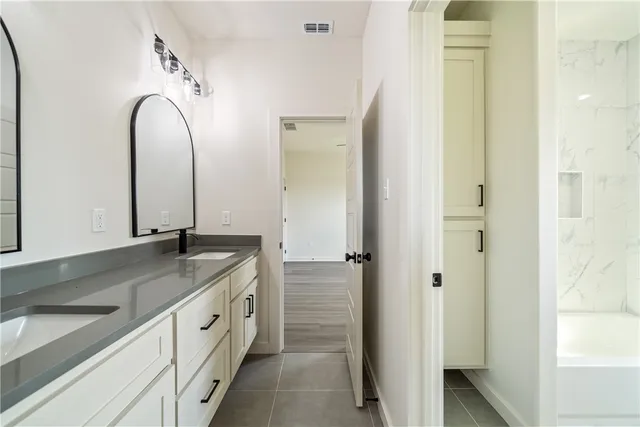 a view of an empty room with wooden floor and a ceiling fan
