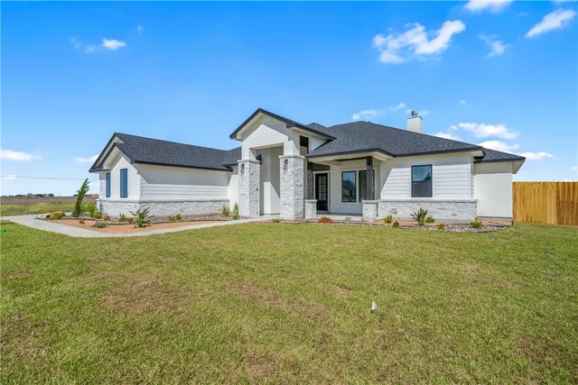 a front view of a house with a garden and yard