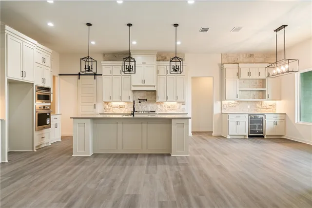 a large kitchen with stainless steel appliances lots of counter space and wooden floor