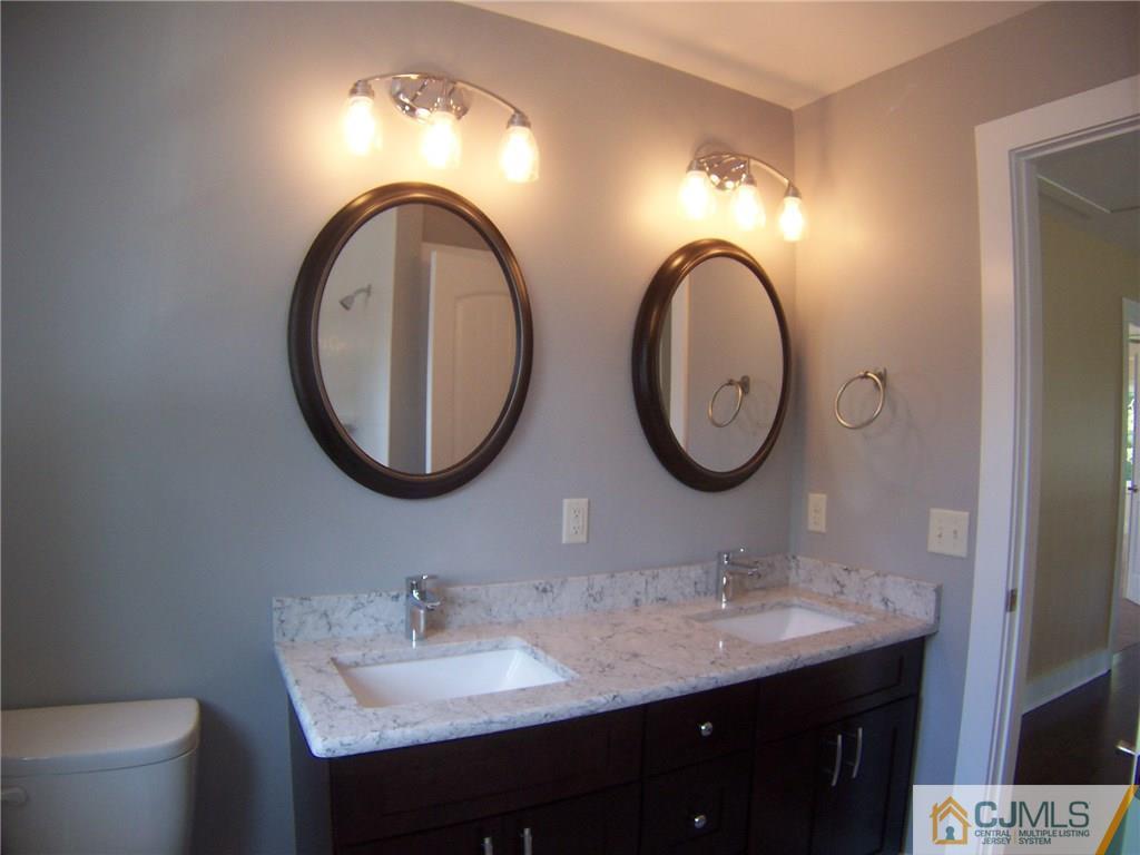24 South Hill Road Colonia, NJ 07067 - Photo 22 of 25 a bathroom with a granite countertop toilet a sink and a mirror