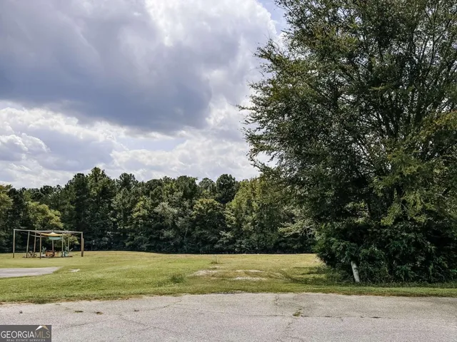 a view of a tennis ground with trees in the background