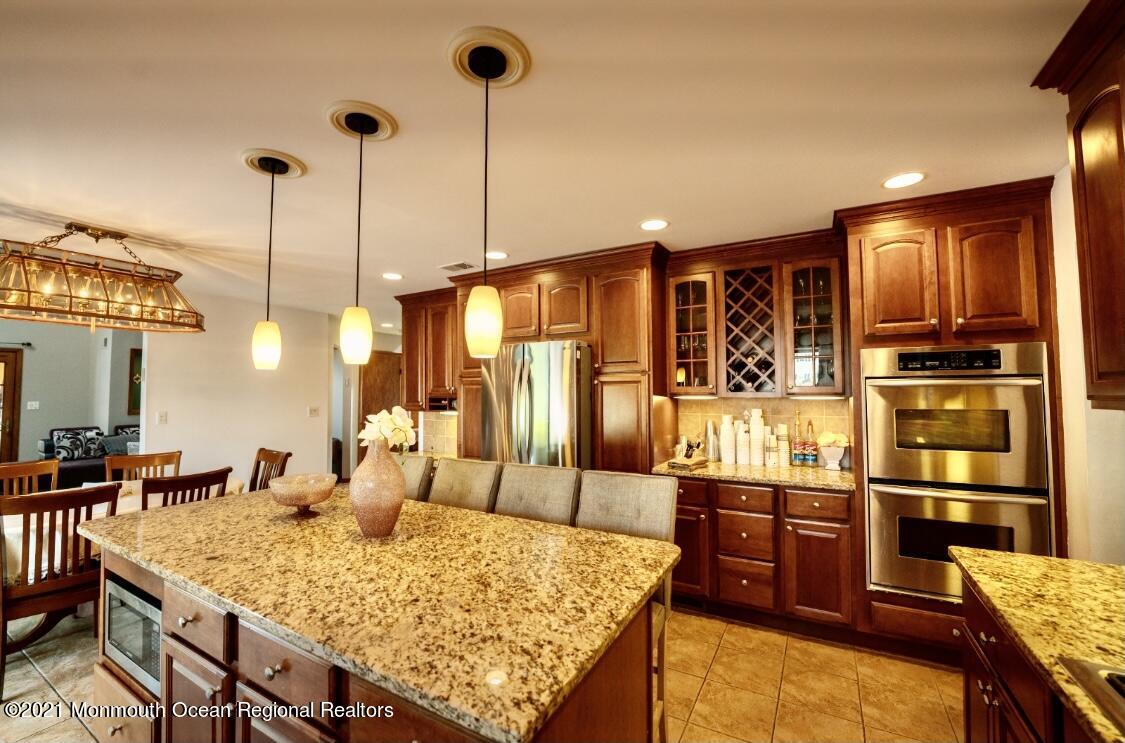 1706 Fanwood Street Oakhurst, NJ 07755 - Photo 4 of 26 a kitchen with kitchen island granite countertop wooden cabinets and counter space