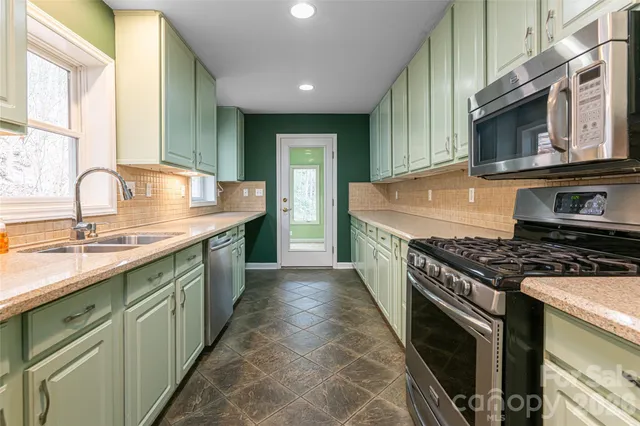 a kitchen with stainless steel appliances granite countertop a stove and a sink