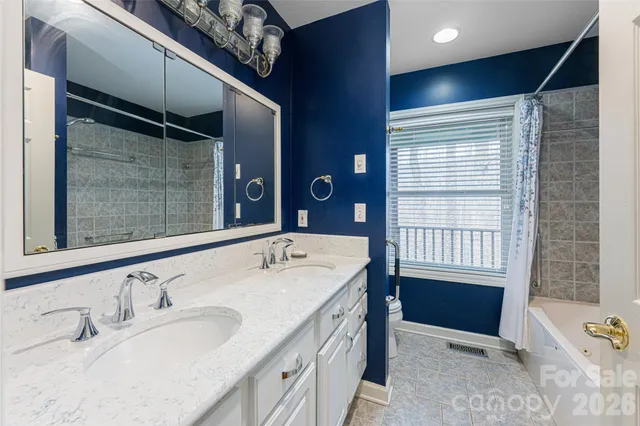 a bathroom with a tub a sink and mirror