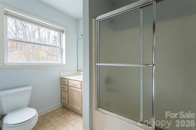 a bathroom with a toilet and a shower