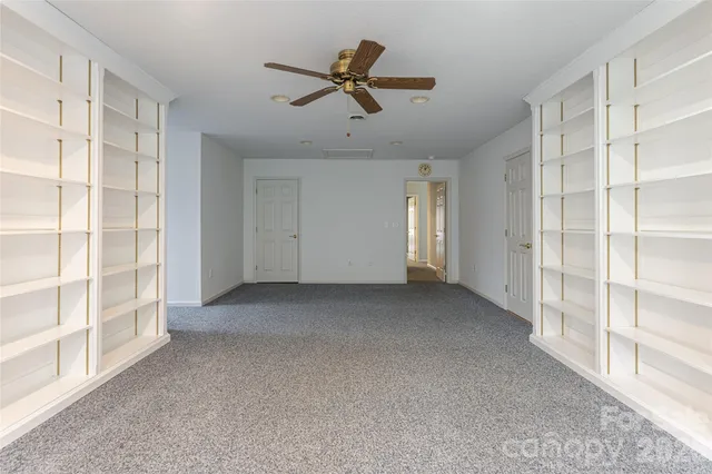 a view of an empty room with cabinet and a window