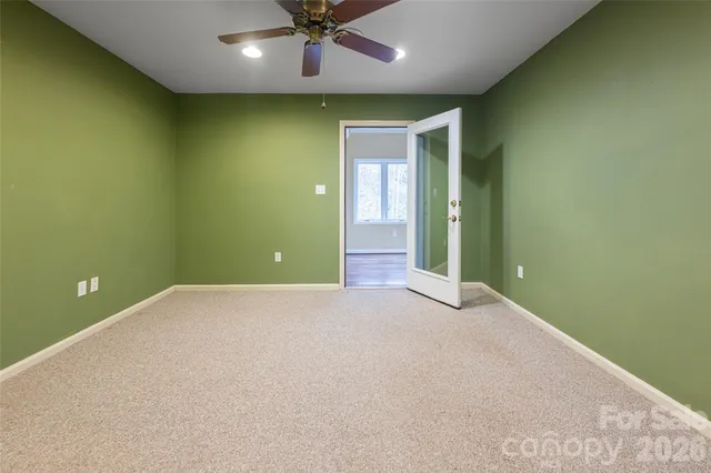 an empty room with a ceiling fan and painted walls