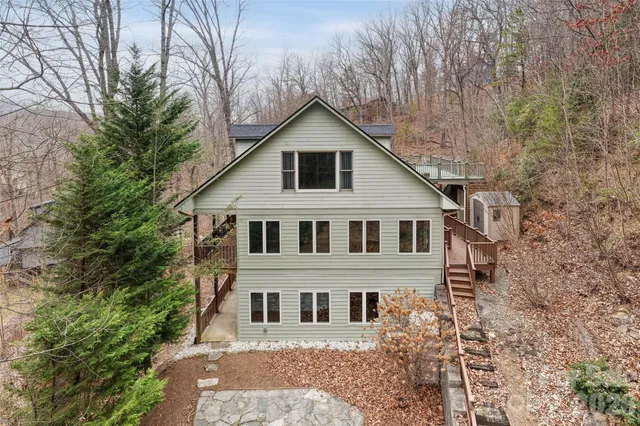 a front view of a house with yard and trees