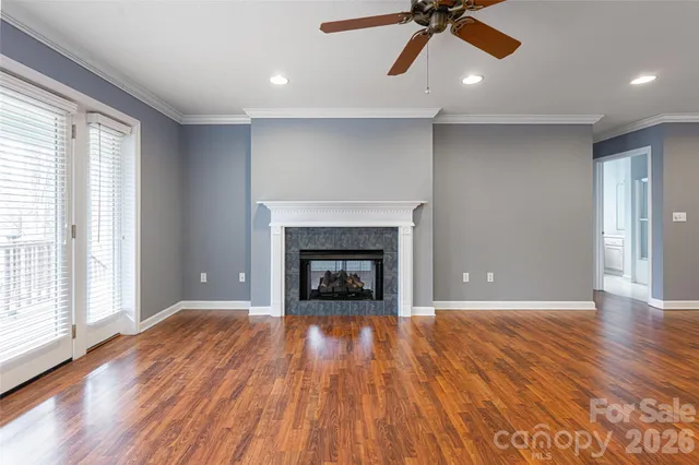 a view of an empty room with a fireplace and window