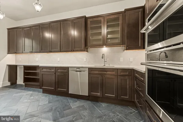 an empty room with wooden floor cabinet and windows