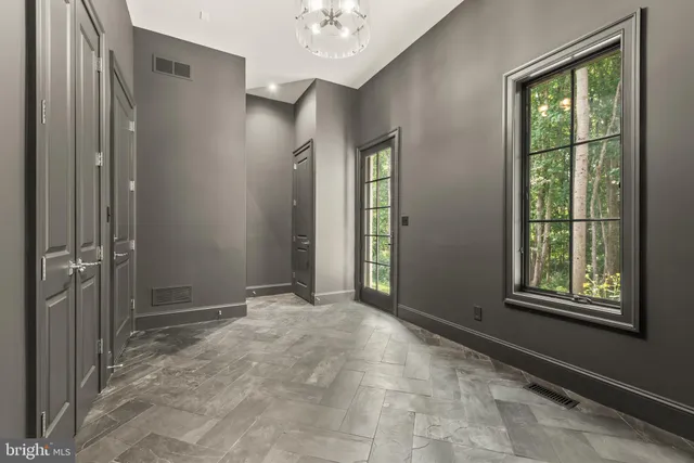 a view of an empty room with wooden floor and closet