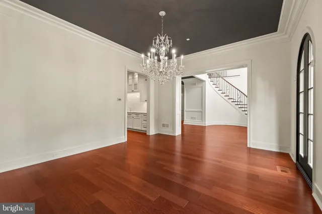 a spacious bedroom with a large bed and a chandelier