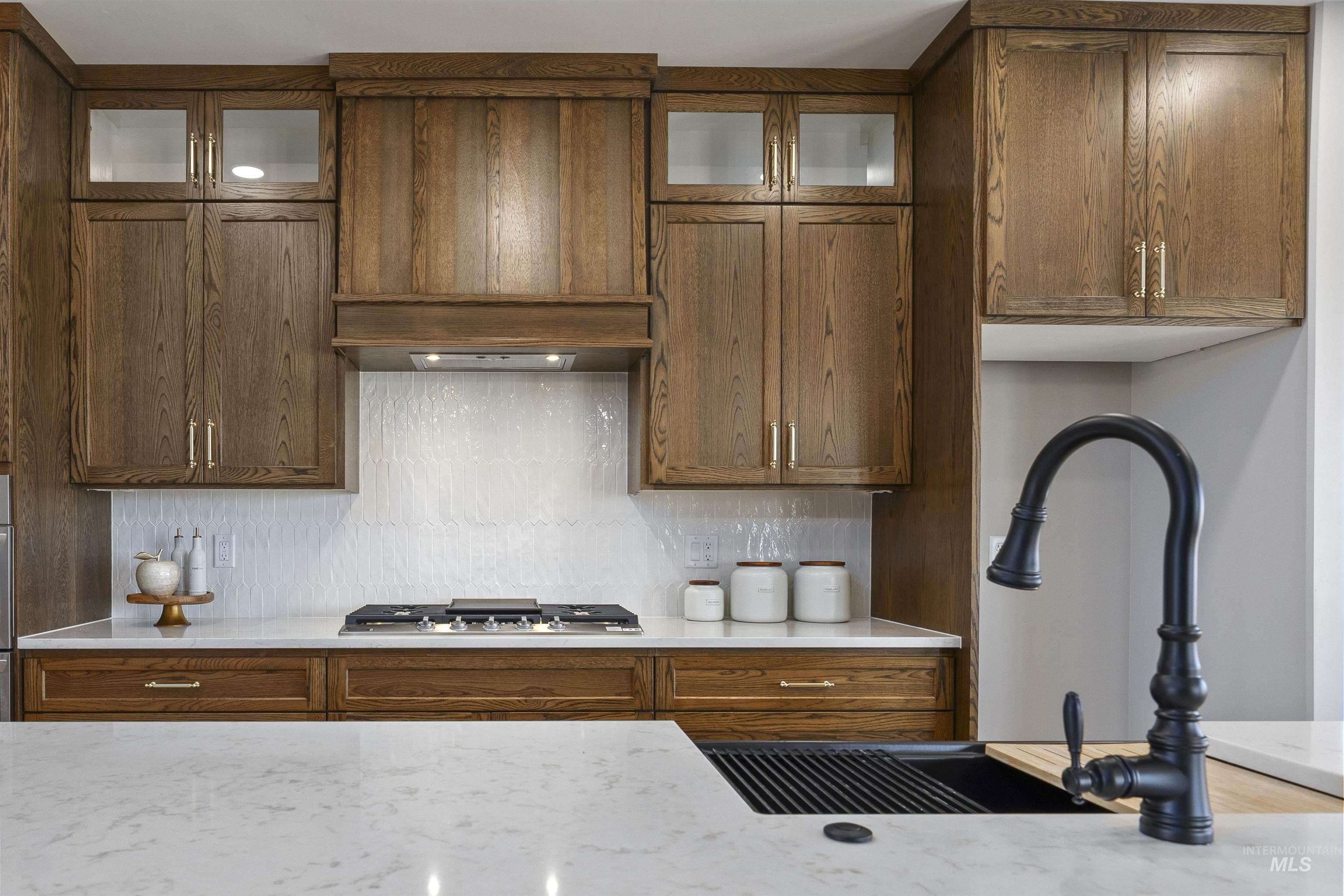 378 West 100 South Rupert, ID 83350 - Photo 14 of 50 Gourmet kitchen featuring custom wood cabinetry, a gas range with integrated ventilation, white subway tile backsplash, and light-toned countertops