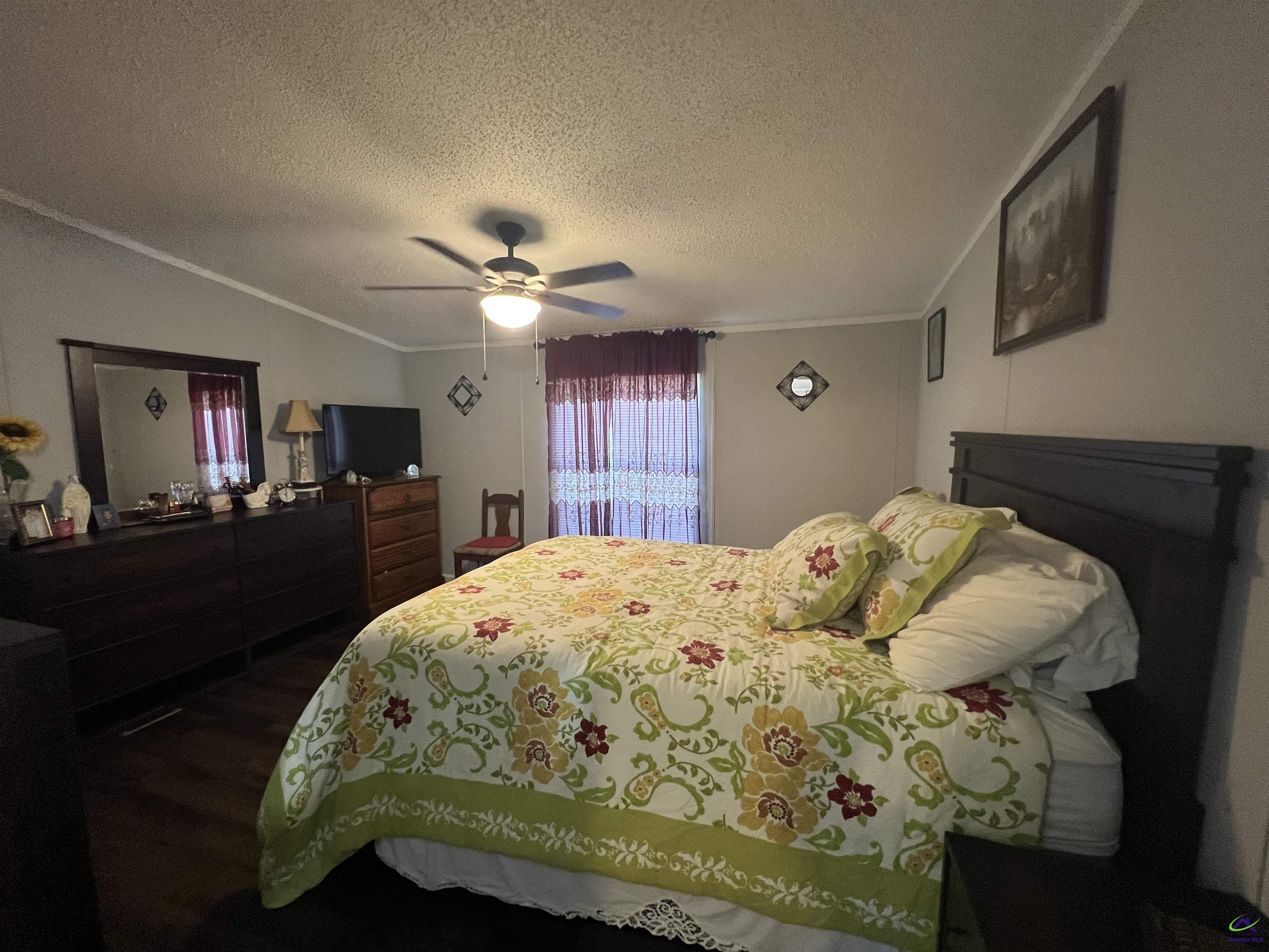 166 Pebble Hills Road Cochran, GA 31014 - Photo 19 of 27 a bedroom with a bed and a chandelier