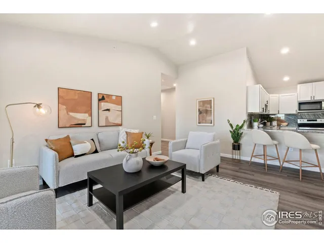 a living room with furniture and a dining table with wooden floor