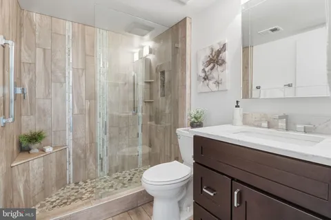 a bathroom with a sink a toilet and shower